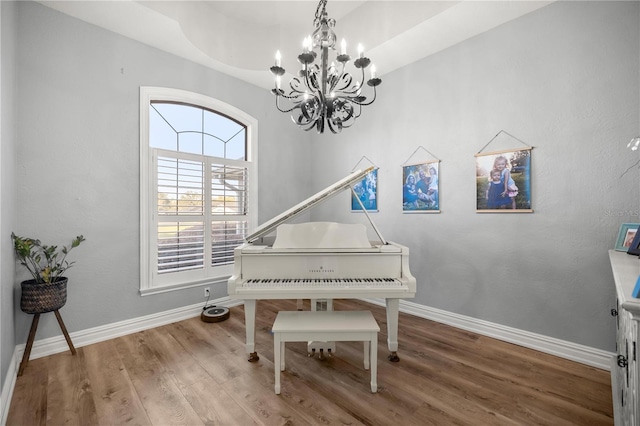 sitting room featuring a notable chandelier, wood finished floors, and baseboards