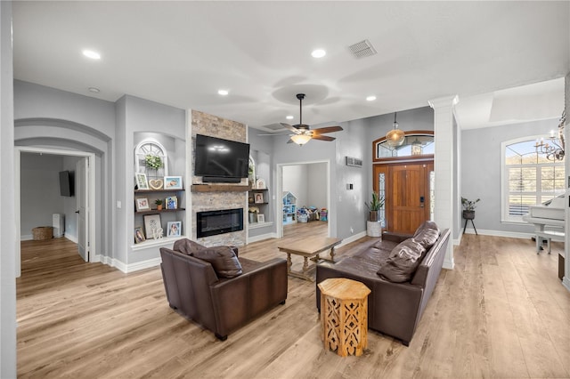 living area featuring visible vents, recessed lighting, a fireplace, ceiling fan with notable chandelier, and light wood-style floors