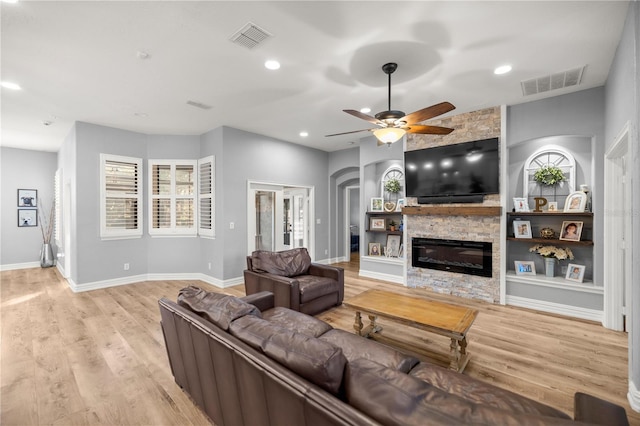 living area featuring recessed lighting, visible vents, wood finished floors, and a fireplace