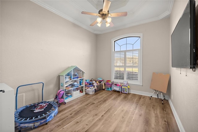 rec room with ceiling fan, crown molding, baseboards, and wood finished floors