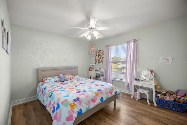 bedroom featuring wood finished floors, baseboards, and ceiling fan