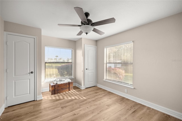 unfurnished bedroom featuring light wood-style floors, baseboards, and ceiling fan