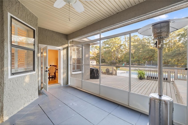 unfurnished sunroom featuring a healthy amount of sunlight and ceiling fan