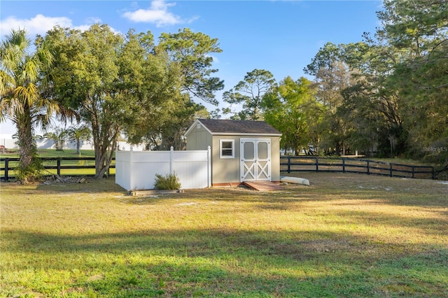 view of yard with an outdoor structure, a storage unit, and fence