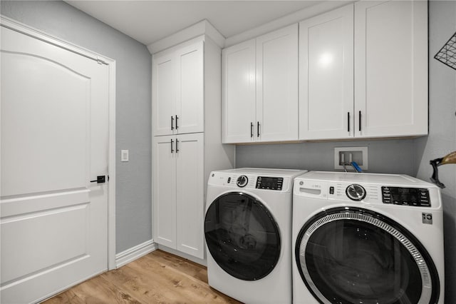 laundry room with washer and dryer, cabinet space, and light wood-type flooring