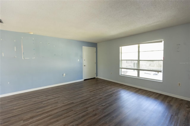 unfurnished room with baseboards, a textured ceiling, and dark wood-style flooring