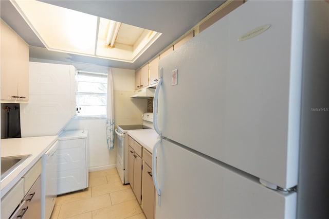 kitchen featuring under cabinet range hood, white appliances, light tile patterned flooring, and light countertops