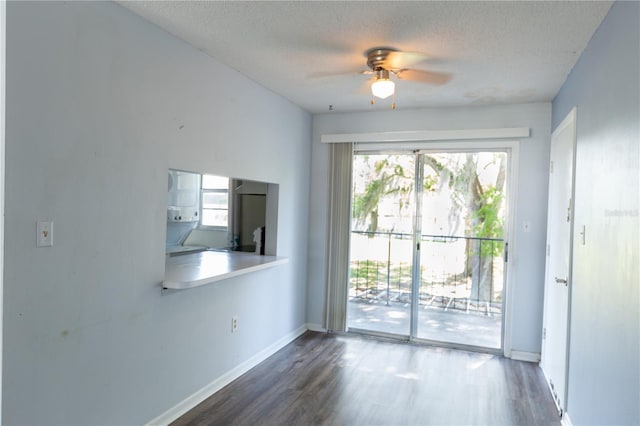 interior space featuring wood finished floors, baseboards, a wealth of natural light, and a textured ceiling