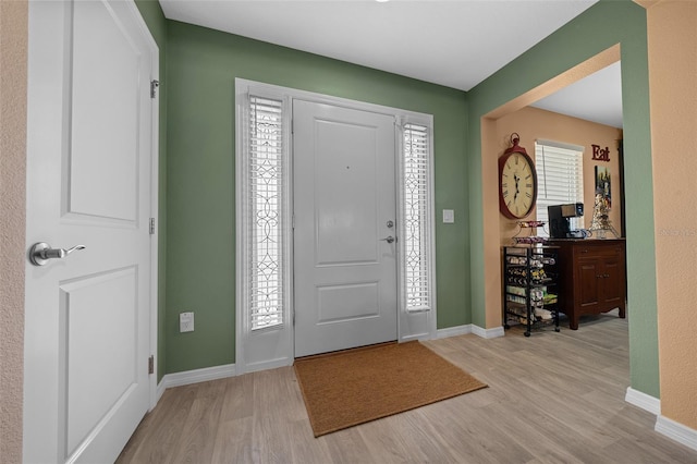 foyer entrance featuring baseboards and light wood finished floors