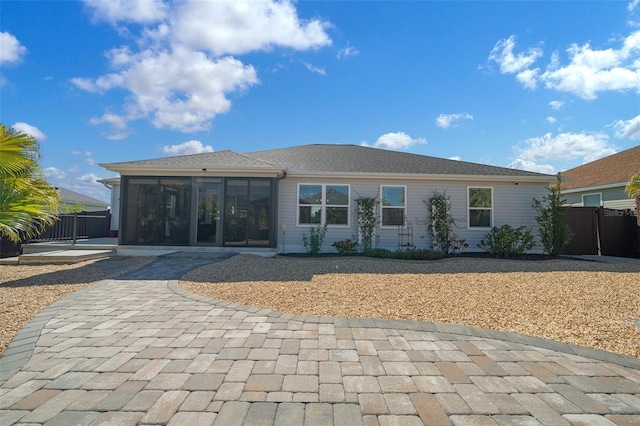 rear view of property with fence and a sunroom