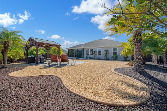 back of property with a gazebo, a sunroom, and a patio area