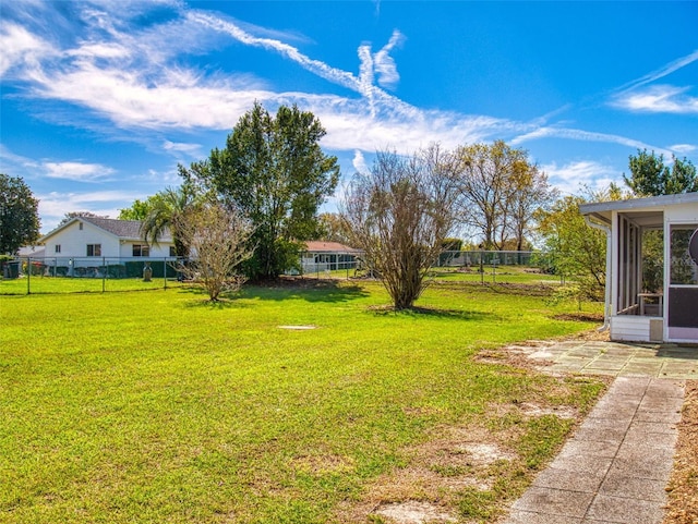 view of yard featuring fence and a sunroom