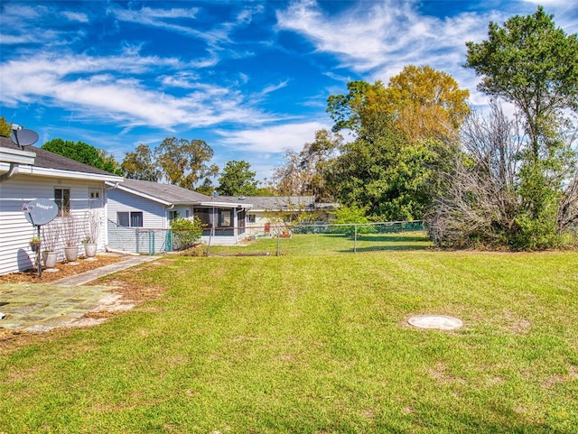 view of yard with a sunroom and fence