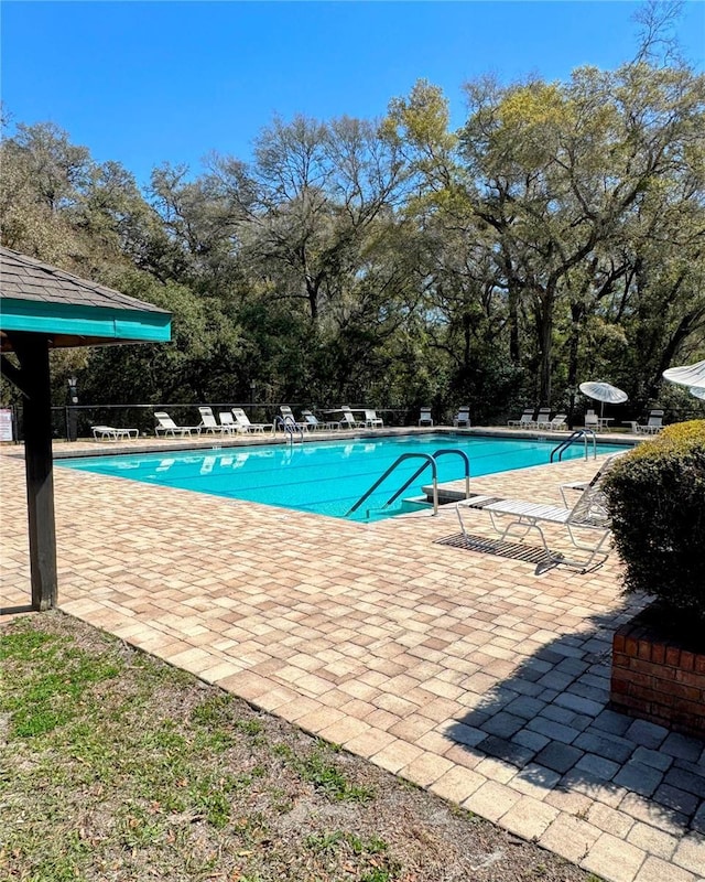 community pool featuring a patio and fence