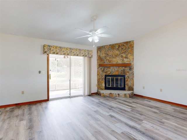 11197 SW 79th Ave, Ocala, FL 34476 - unfurnished living room featuring wood finished floors, a ceiling fan, baseboards, and a stone fireplace
