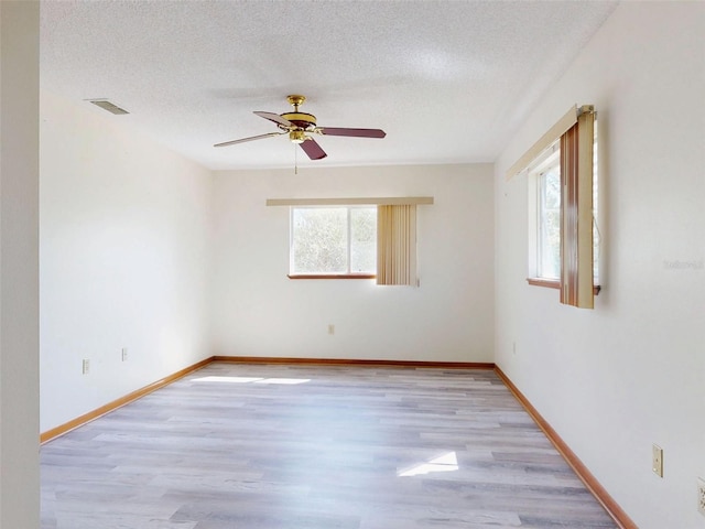 11197 SW 79th Ave, Ocala, FL 34476 - unfurnished room with light wood-style floors, ceiling fan, a textured ceiling, and baseboards