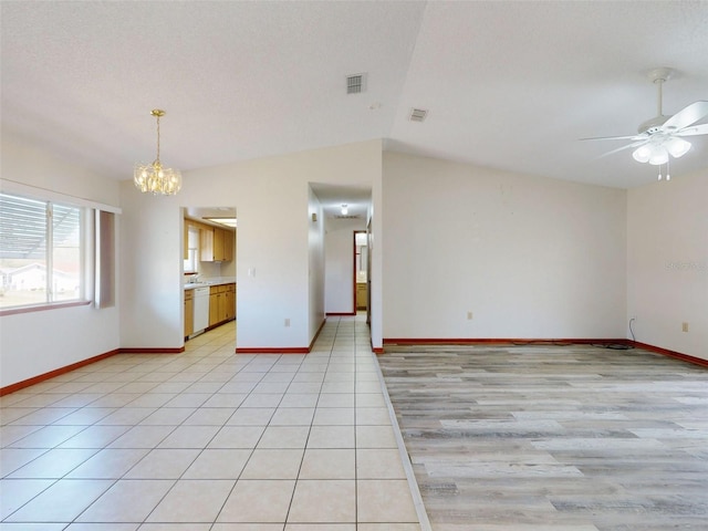 11197 SW 79th Ave, Ocala, FL 34476 - unfurnished living room with a chandelier, a ceiling fan, baseboards, vaulted ceiling, and light tile patterned floors