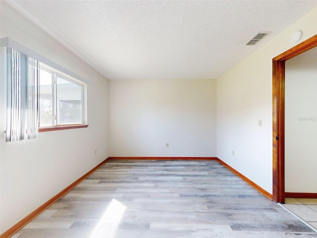 11197 SW 79th Ave, Ocala, FL 34476 - empty room with a textured ceiling, light wood finished floors, and baseboards