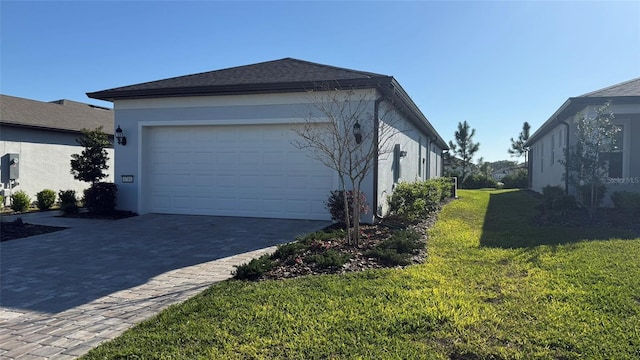 view of property exterior with an attached garage, a yard, driveway, and stucco siding