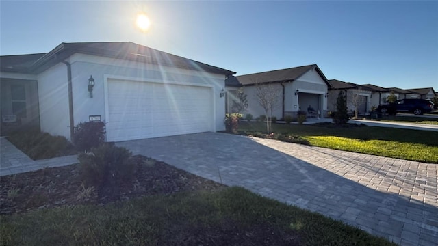 ranch-style home with decorative driveway and a garage