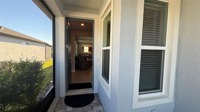 doorway to property featuring stucco siding