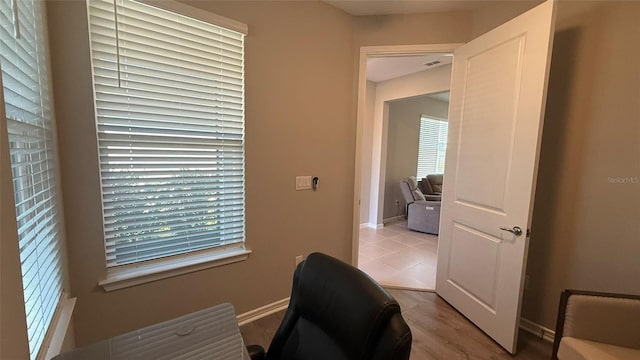 office area with visible vents, light wood-type flooring, and baseboards