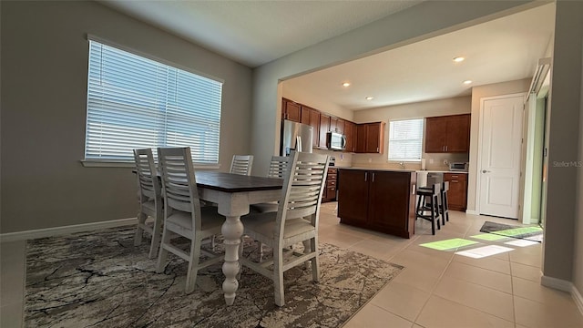 dining room featuring light tile patterned floors, baseboards, and recessed lighting