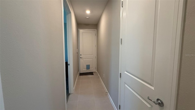 hallway with baseboards and light tile patterned flooring