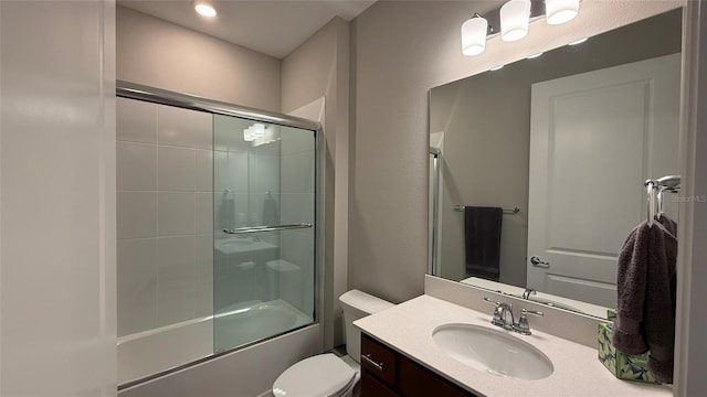 bathroom featuring bath / shower combo with glass door, toilet, and vanity