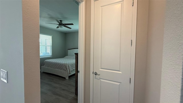 hall with a textured wall and wood finished floors