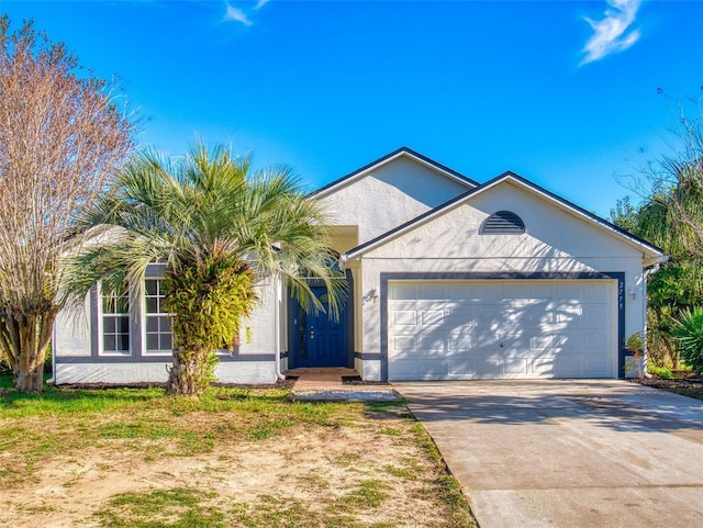 ranch-style home featuring an attached garage, driveway, and stucco siding