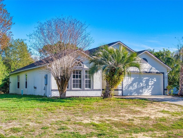 single story home with a front yard, concrete driveway, a garage, and stucco siding