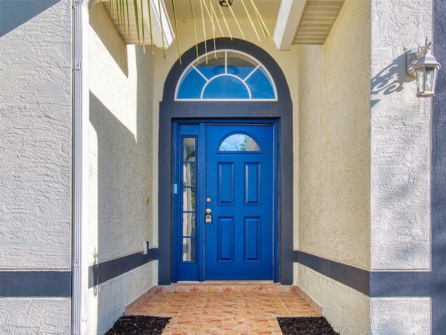 entrance to property featuring stucco siding