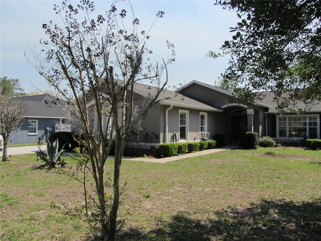 ranch-style home featuring stucco siding and a front lawn