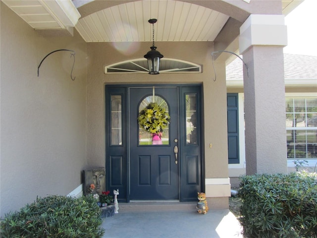 view of exterior entry with stucco siding