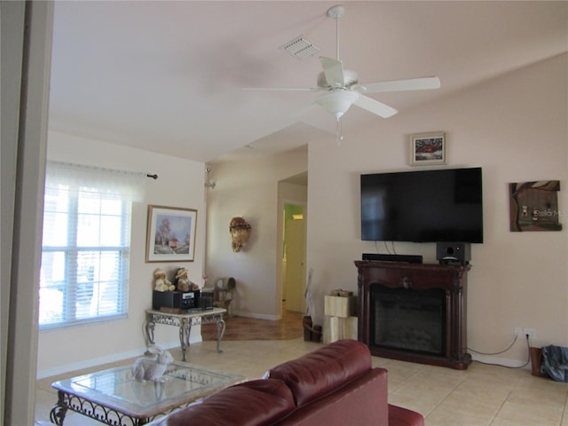 living room with visible vents, light tile patterned flooring, a fireplace, ceiling fan, and vaulted ceiling