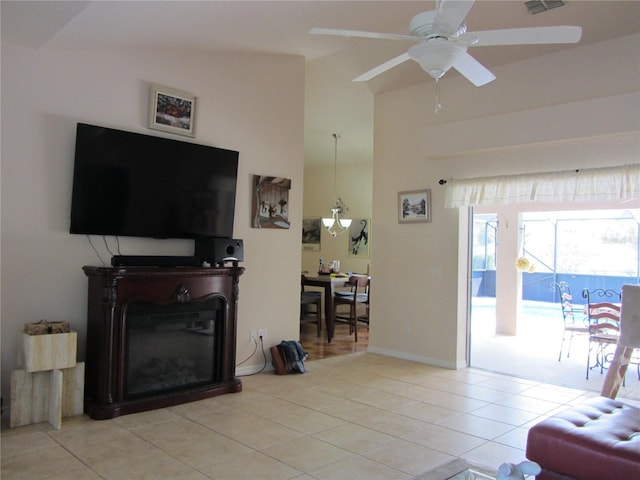 living area featuring tile patterned floors, visible vents, baseboards, and ceiling fan