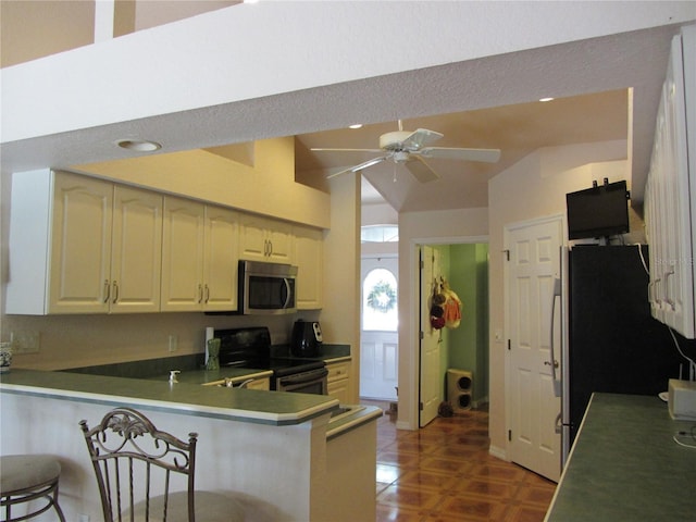 kitchen featuring a breakfast bar area, recessed lighting, a peninsula, stainless steel appliances, and a ceiling fan