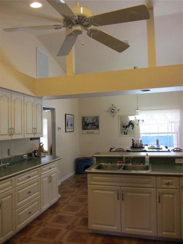 kitchen with a ceiling fan, visible vents, high vaulted ceiling, plenty of natural light, and a sink