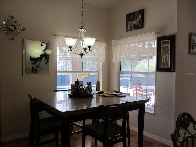 dining area with a notable chandelier, a healthy amount of sunlight, and baseboards