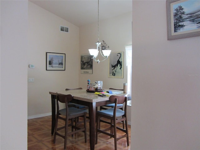 dining area with an inviting chandelier, baseboards, visible vents, and vaulted ceiling