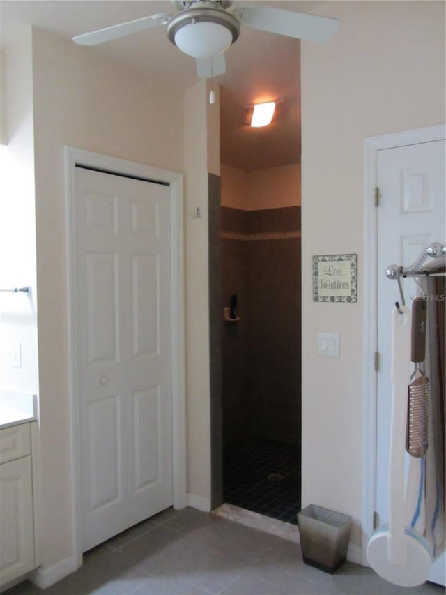 interior space featuring tile patterned floors, a ceiling fan, and a stall shower