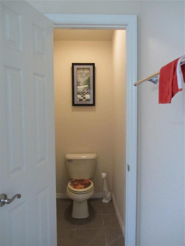 bathroom with tile patterned floors, baseboards, and toilet