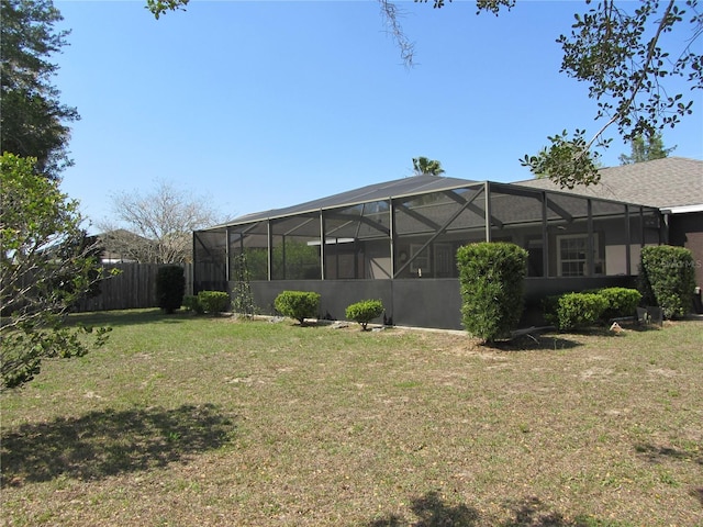 view of yard featuring glass enclosure and fence