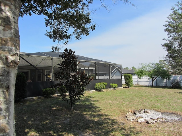 view of yard with a lanai and fence