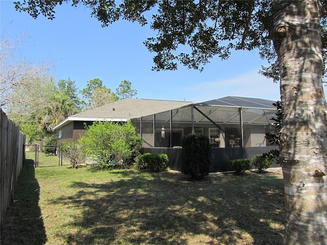 view of yard with glass enclosure, a gate, and fence private yard