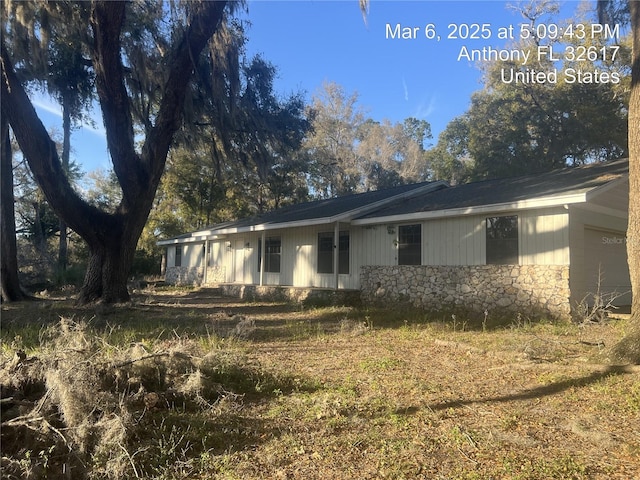 back of house with stone siding