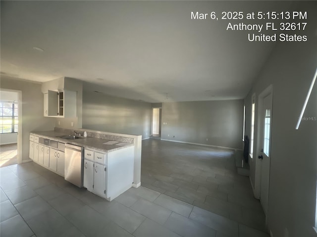 kitchen with a sink, white cabinetry, light countertops, baseboards, and dishwasher