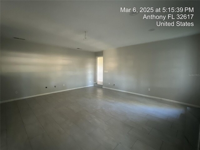 unfurnished room with visible vents and baseboards