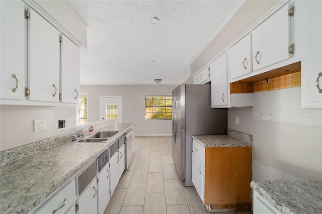 9951 NE 30th Ct, Anthony, FL 32617 - kitchen featuring baseboards, a textured ceiling, a sink, white cabinets, and appliances with stainless steel finishes